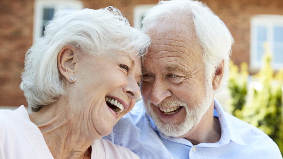 Elderly couple smiling at assisted living home